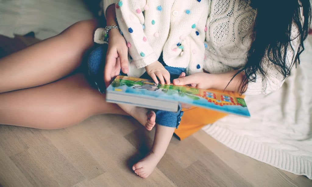 mother reading book with kid