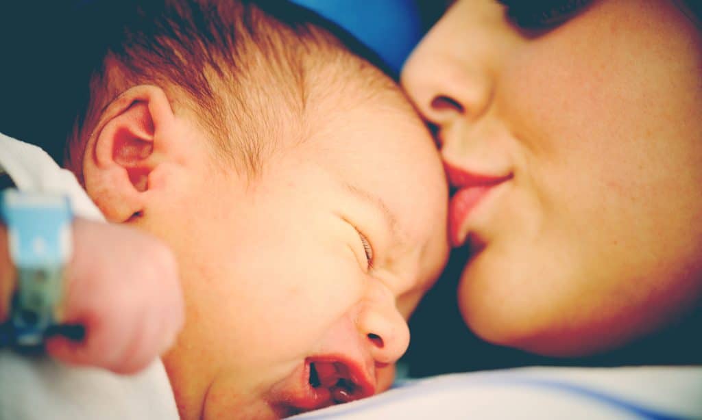 mother kiss newborn at hospital
