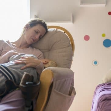 tired mother with kid in kid's room