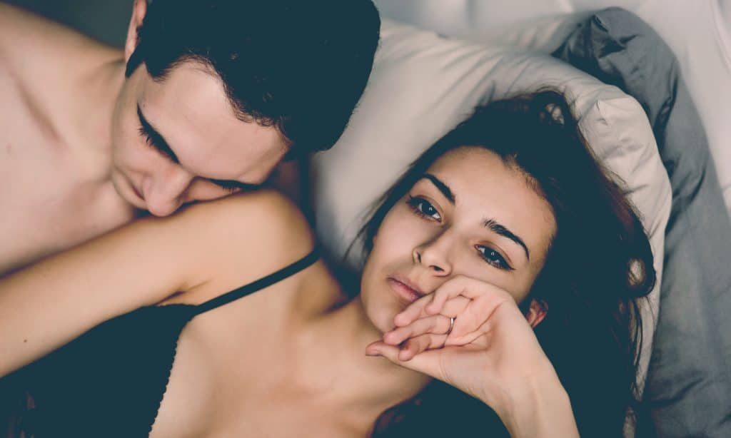 sad woman with man in bed
