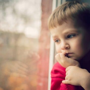 enfant triste attend fenêtre