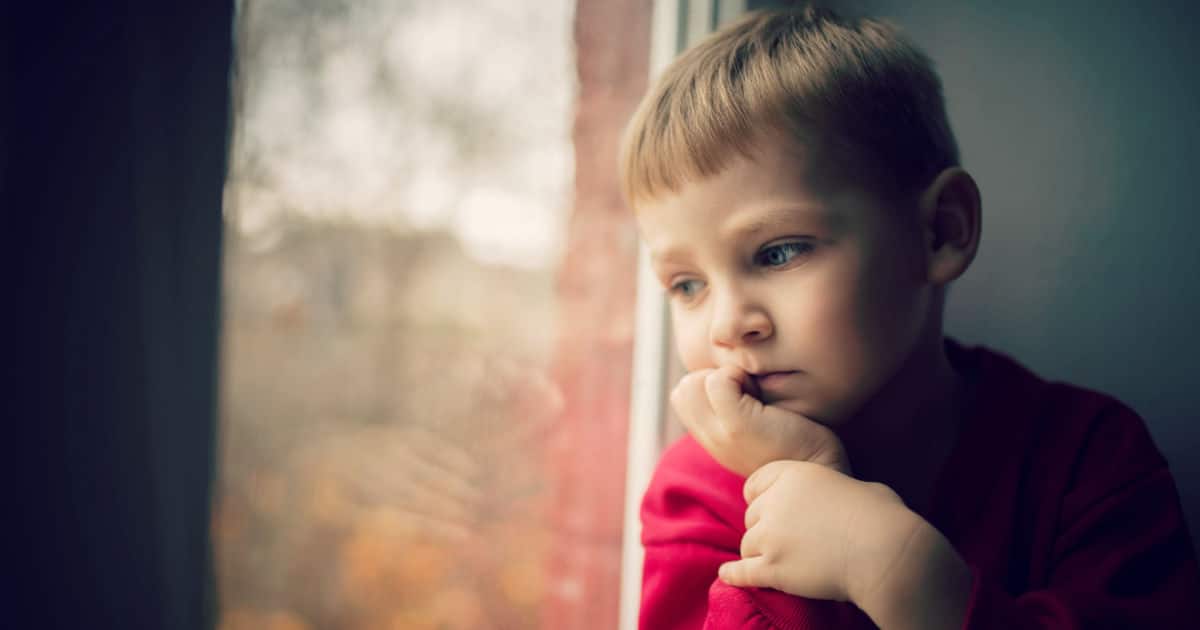 enfant triste attend fenêtre