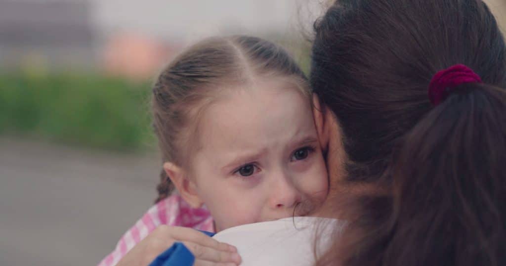fillette qui pleure dans les bras de sa mère