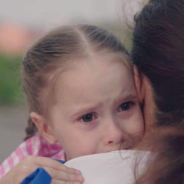 fillette qui pleure dans les bras de sa mère